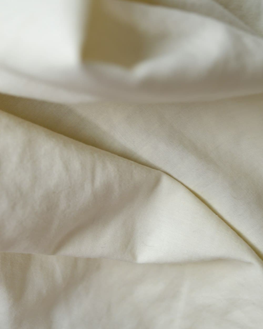 Warm ivory silk-cotton fabric gathered in soft folds