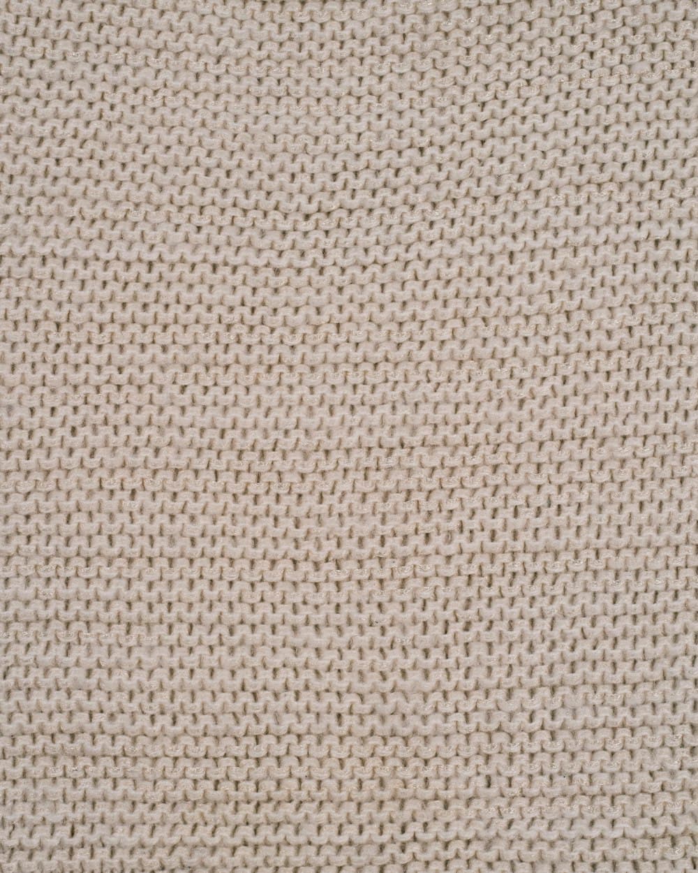 Close-up of fine ribbed knit fabric in a warm sand tone