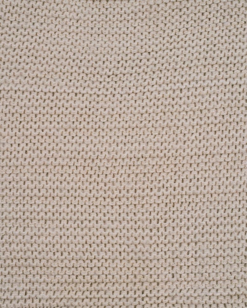 Warm sand-colored fine knit texture, close-up