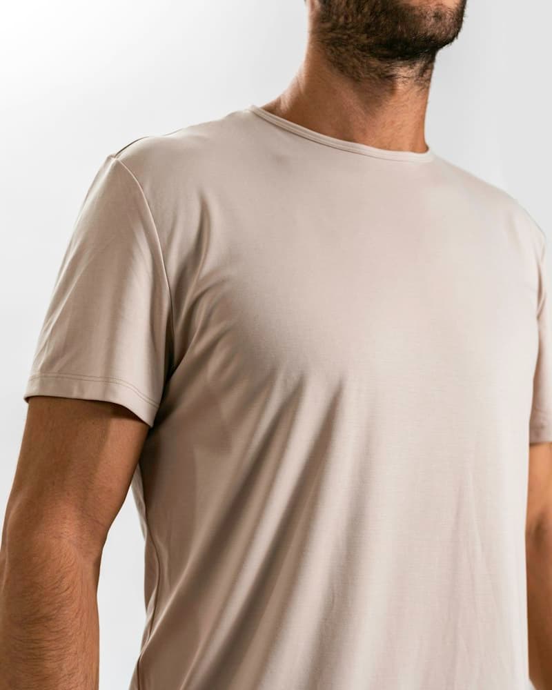 Man wearing a stone-colored crew-neck undershirt in studio light